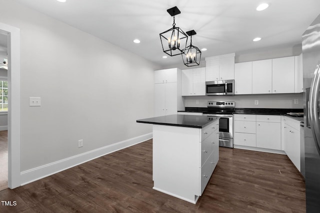 216 Whitfield St, Enfield, NC 27823 - kitchen with appliances with stainless steel finishes, dark countertops, recessed lighting, a kitchen island, and dark wood-type flooring