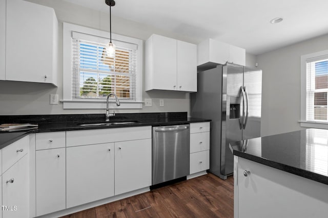 216 Whitfield St, Enfield, NC 27823 - kitchen with appliances with stainless steel finishes, dark wood-type flooring, white cabinetry, and decorative light fixtures
