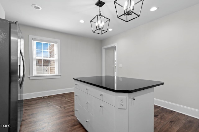 216 Whitfield St, Enfield, NC 27823 - kitchen with stainless steel fridge with ice dispenser, a chandelier, dark countertops, a kitchen island, and dark wood-style flooring