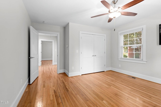 216 Whitfield St, Enfield, NC 27823 - unfurnished bedroom featuring light wood-style flooring, a closet, and a ceiling fan