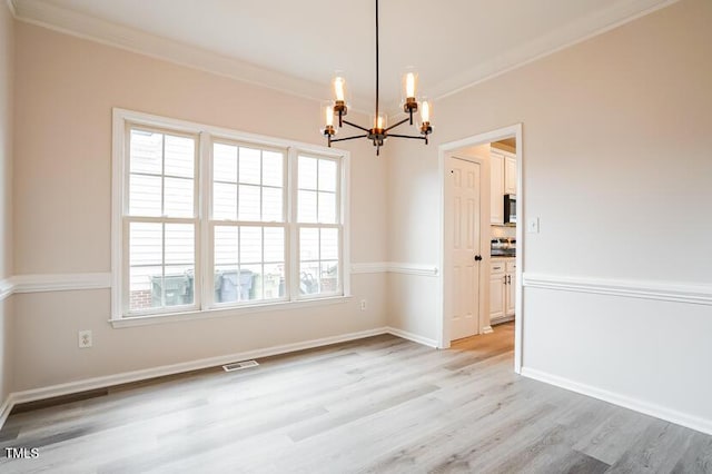5933 Big Nance Dr, Raleigh, NC 27616 - unfurnished dining area featuring a chandelier, ornamental molding, light wood-type flooring, and healthy amount of natural light