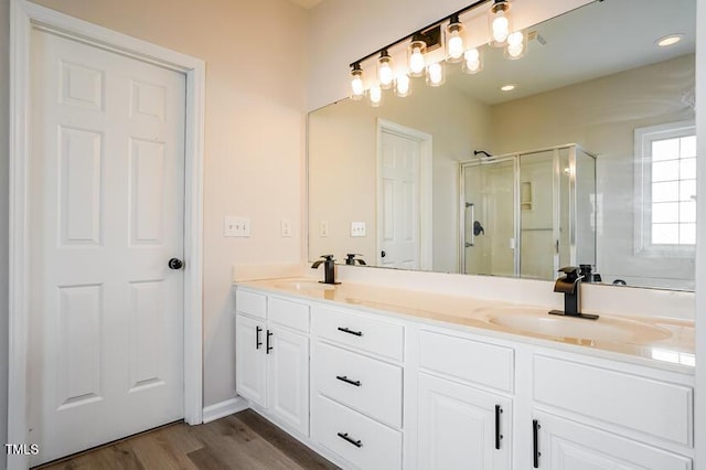 5933 Big Nance Dr, Raleigh, NC 27616 - bathroom featuring double vanity, a stall shower, and wood finished floors