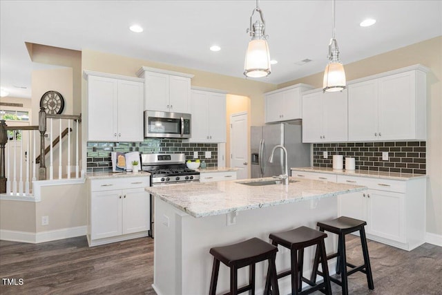1119 Latitude Dr, Durham, NC 27713 - kitchen with appliances with stainless steel finishes, dark wood-style flooring, white cabinetry, backsplash, and recessed lighting