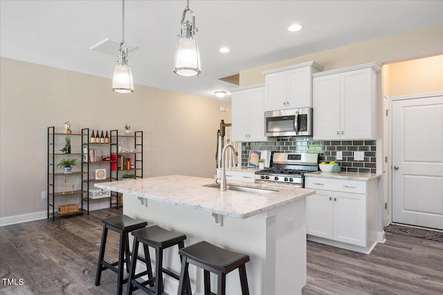 1119 Latitude Dr, Durham, NC 27713 - kitchen with stainless steel appliances, dark wood finished floors, white cabinetry, tasteful backsplash, and recessed lighting