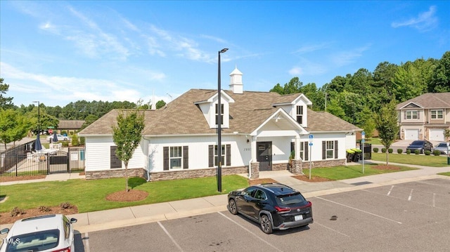 1119 Latitude Dr, Durham, NC 27713 - view of front of house with stone siding, uncovered parking, a gate, and a shingled roof