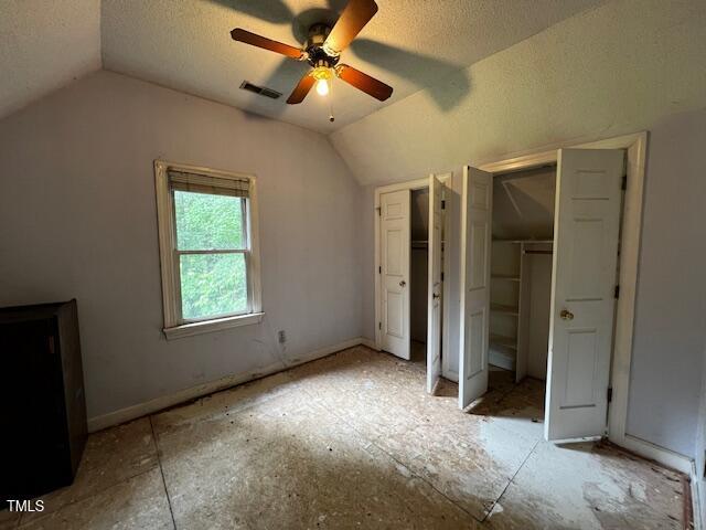 3573 River View Cir, Oxford, NC 27565 - unfurnished bedroom with vaulted ceiling, a textured ceiling, multiple closets, and ceiling fan