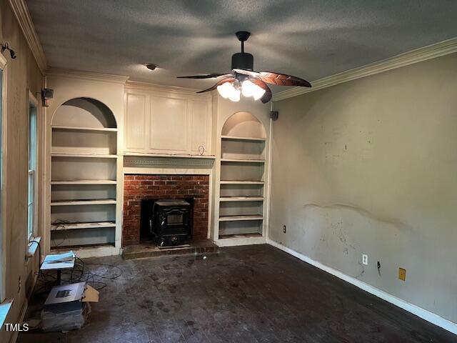 3573 River View Cir, Oxford, NC 27565 - unfurnished living room featuring a wood stove, built in shelves, a ceiling fan, and ornamental molding