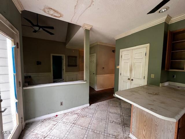 3573 River View Cir, Oxford, NC 27565 - kitchen with plenty of natural light, a textured ceiling, a wainscoted wall, and crown molding