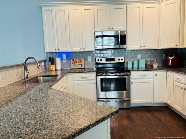 914 W Rowan St SW, Fayetteville, NC 28301 - kitchen featuring stainless steel appliances, a peninsula, tasteful backsplash, dark stone countertops, and white cabinetry
