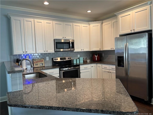 914 W Rowan St SW, Fayetteville, NC 28301 - kitchen featuring appliances with stainless steel finishes, a peninsula, dark stone counters, crown molding, and tasteful backsplash