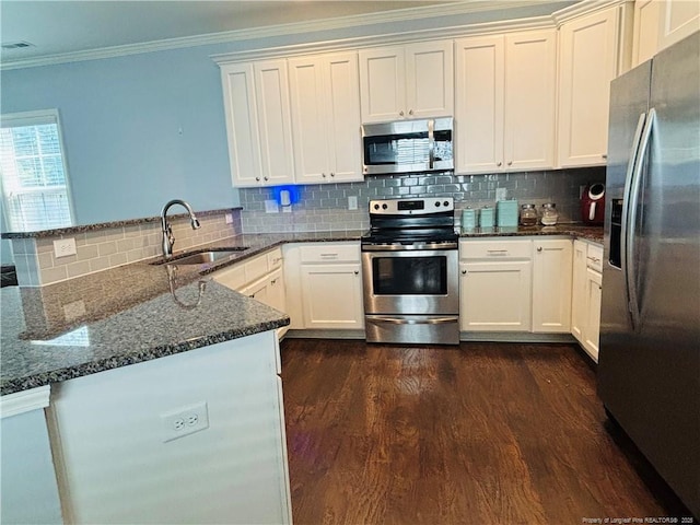 914 W Rowan St SW, Fayetteville, NC 28301 - kitchen with appliances with stainless steel finishes, a peninsula, ornamental molding, decorative backsplash, and dark wood-style floors