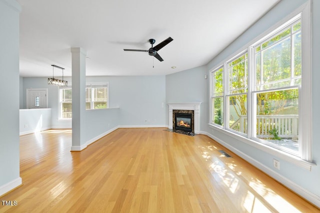 203 Bluefield Rd, Chapel Hill, NC 27517 - unfurnished living room with light wood-style floors, a premium fireplace, and a ceiling fan