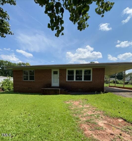 2035 Simpkins Rd, Raleigh, NC 27603 - view of front facade with brick siding, an attached carport, driveway, and a front lawn