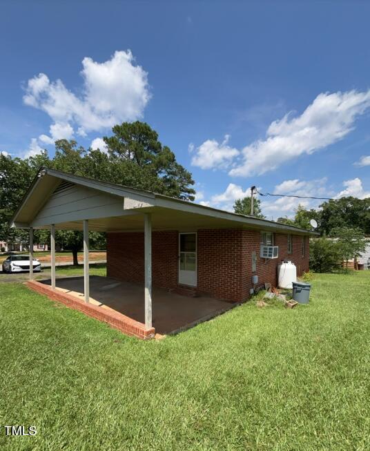 2035 Simpkins Rd, Raleigh, NC 27603 - view of property exterior featuring a yard, brick siding, and a patio