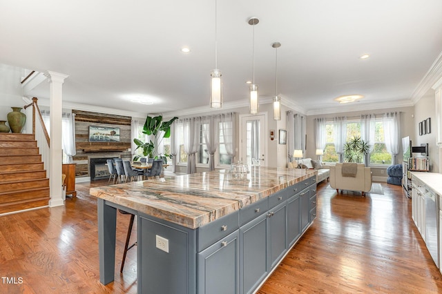 1501 Heritage Reserve Ct, Wake Forest, NC 27587 - kitchen featuring open floor plan, gray cabinets, crown molding, wood finished floors, and a fireplace