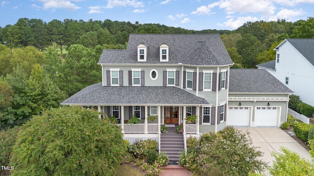 1501 Heritage Reserve Ct, Wake Forest, NC 27587 - view of front of property featuring covered porch, concrete driveway, roof with shingles, an attached garage, and a view of trees