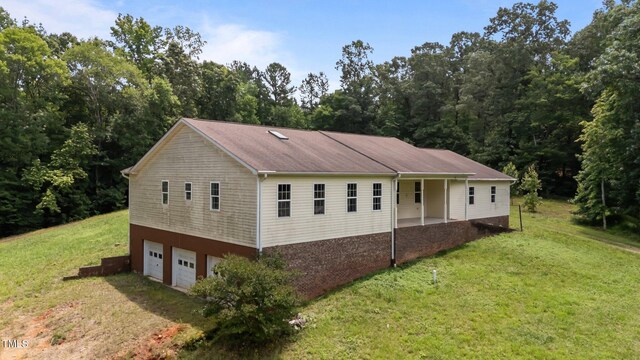 129 Shaman Dr, Louisburg, NC 27549 - view of side of home with a lawn, a garage, and driveway