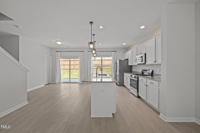 5404 Rutledgeville Ln, Knightdale, NC 27545 - kitchen featuring appliances with stainless steel finishes, light wood finished floors, white cabinetry, light stone countertops, and recessed lighting