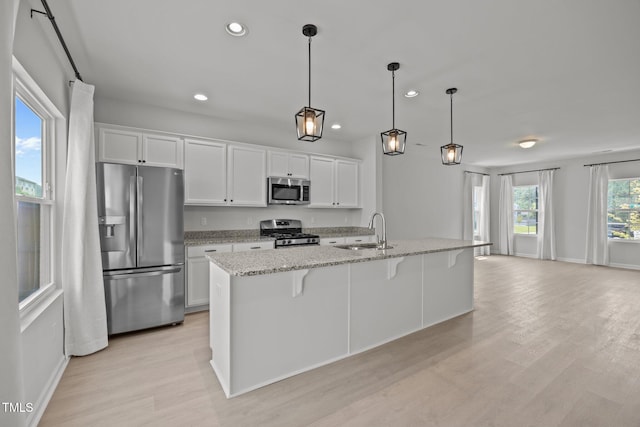 5404 Rutledgeville Ln, Knightdale, NC 27545 - kitchen with stainless steel appliances, recessed lighting, light wood finished floors, white cabinetry, and a kitchen breakfast bar