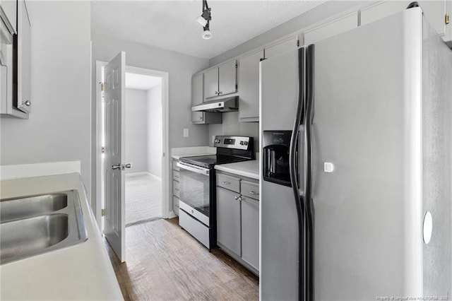 3326 Donnett Dr, Spring Lake, NC 28390 - kitchen with appliances with stainless steel finishes, under cabinet range hood, wood finished floors, light countertops, and gray cabinets