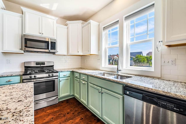 438 Granite Mill Blvd, Chapel Hill, NC 27516 - kitchen with stainless steel appliances, green cabinetry, white cabinetry, dark wood finished floors, and backsplash