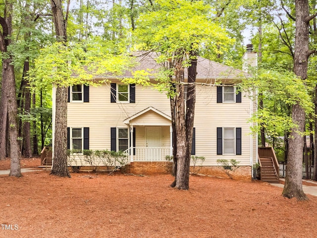 4316 American Dr, Durham, NC 27705 - colonial home featuring a chimney, stairs, and covered porch