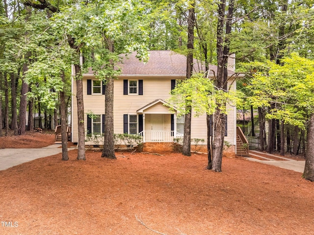 4316 American Dr, Durham, NC 27705 - colonial house featuring covered porch, stairway, and a shingled roof