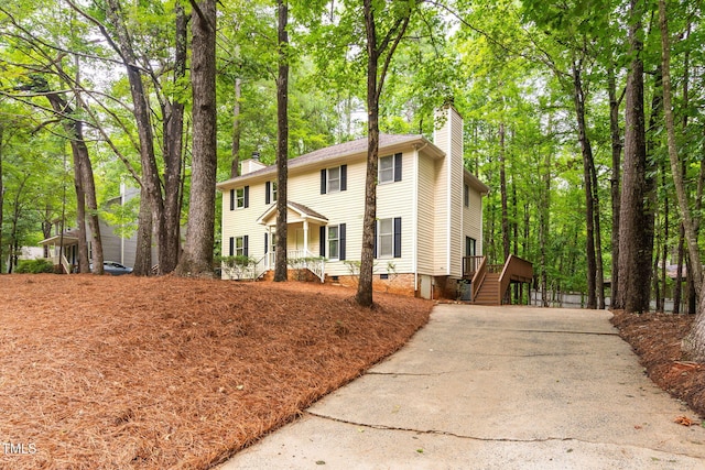 4316 American Dr, Durham, NC 27705 - colonial-style house featuring a chimney, concrete driveway, stairway, and crawl space