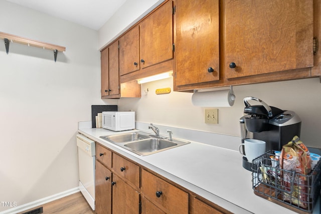 4316 American Dr, Durham, NC 27705 - kitchen with white appliances, brown cabinetry, light countertops, and light wood finished floors