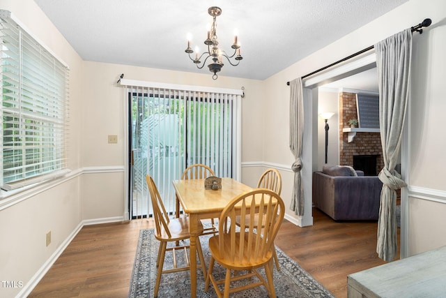 4316 American Dr, Durham, NC 27705 - dining space with a chandelier, wood finished floors, and a brick fireplace