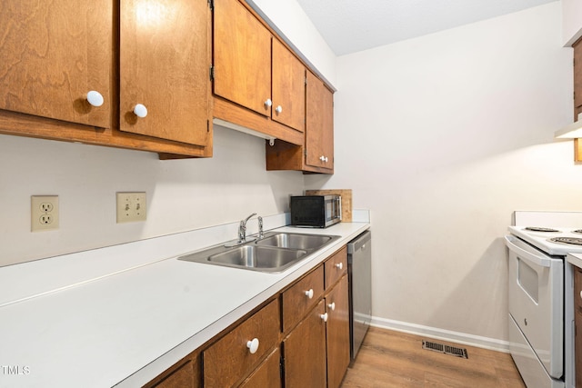 4316 American Dr, Durham, NC 27705 - kitchen featuring white electric stove, dishwasher, light countertops, brown cabinets, and light wood finished floors