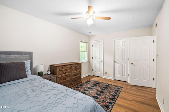 4316 American Dr, Durham, NC 27705 - bedroom featuring wood finished floors, two closets, and a ceiling fan