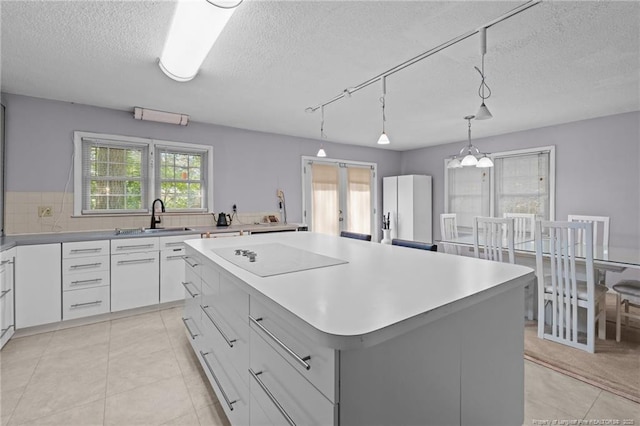 5945 Muscat Rd, Hope Mills, NC 28348 - kitchen with electric stovetop, a center island, a textured ceiling, healthy amount of natural light, and light tile patterned floors