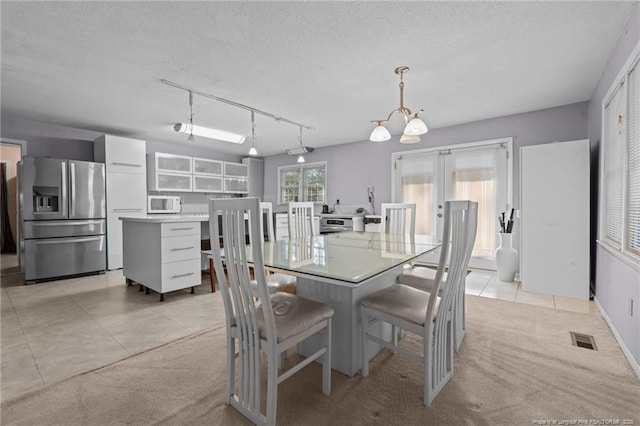 5945 Muscat Rd, Hope Mills, NC 28348 - dining room featuring light tile patterned flooring, a chandelier, a textured ceiling, and track lighting