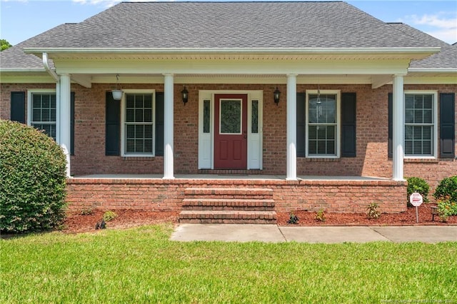1438 Division Pl, Fayetteville, NC 28312 - doorway to property with brick siding, a shingled roof, a yard, and covered porch