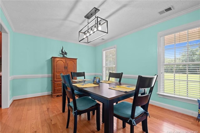 1438 Division Pl, Fayetteville, NC 28312 - dining area featuring light wood-style flooring, a textured ceiling, and ornamental molding