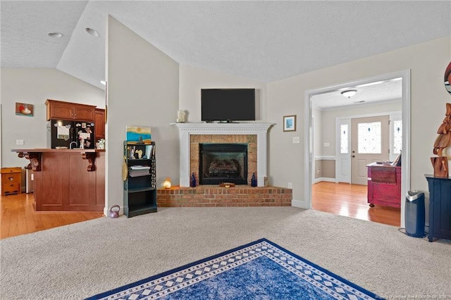 1438 Division Pl, Fayetteville, NC 28312 - living area with vaulted ceiling, a fireplace, and light colored carpet