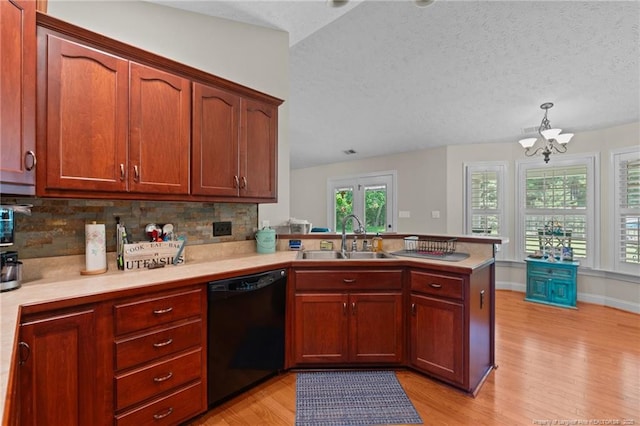 1438 Division Pl, Fayetteville, NC 28312 - kitchen featuring black dishwasher, light wood-style floors, a peninsula, light countertops, and backsplash