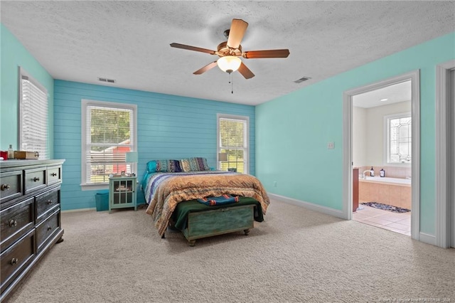 1438 Division Pl, Fayetteville, NC 28312 - bedroom with a textured ceiling, multiple windows, carpet flooring, a ceiling fan, and connected bathroom