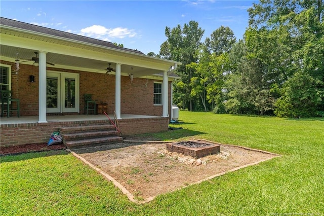 1438 Division Pl, Fayetteville, NC 28312 - view of green lawn with a ceiling fan, a patio area, an outdoor fire pit, and french doors