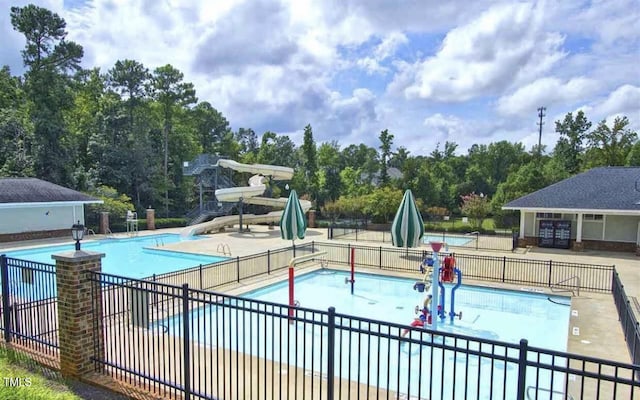 5004 Sunset Forest Cir, Holly Springs, NC 27540 - community pool featuring a water slide, a water play area, a patio area, and view of scattered trees