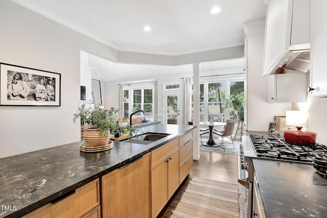5004 Sunset Forest Cir, Holly Springs, NC 27540 - kitchen with stainless steel gas range oven, plenty of natural light, wall chimney exhaust hood, light wood-style floors, and recessed lighting