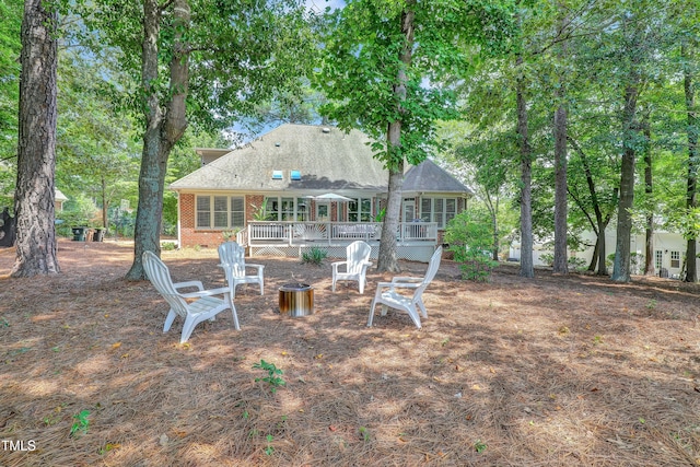 5004 Sunset Forest Cir, Holly Springs, NC 27540 - back of house with a deck, brick siding, and a fire pit