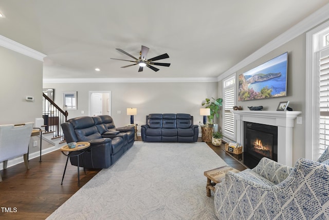 210 Meadow Lake Dr, Youngsville, NC 27596 - living area featuring dark wood finished floors, a ceiling fan, crown molding, a fireplace with flush hearth, and stairway