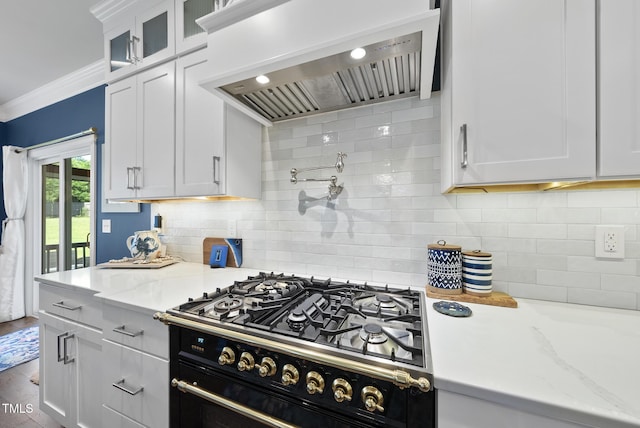210 Meadow Lake Dr, Youngsville, NC 27596 - kitchen featuring wall chimney exhaust hood, white cabinetry, crown molding, cooktop, and backsplash