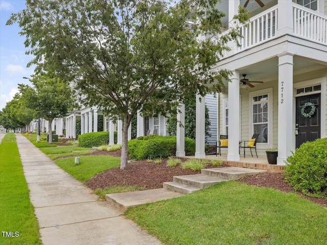 7712 Acc Blvd, Raleigh, NC 27617 - view of exterior entry with covered porch, a ceiling fan, a yard, and a balcony