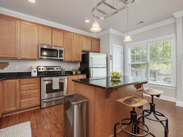 7712 Acc Blvd, Raleigh, NC 27617 - kitchen featuring appliances with stainless steel finishes, a kitchen bar, dark wood finished floors, crown molding, and a center island