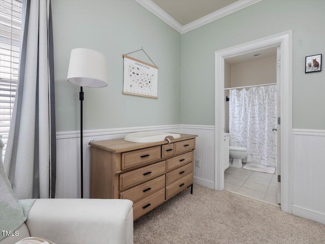 7712 Acc Blvd, Raleigh, NC 27617 - bedroom featuring a wainscoted wall, crown molding, light carpet, and connected bathroom