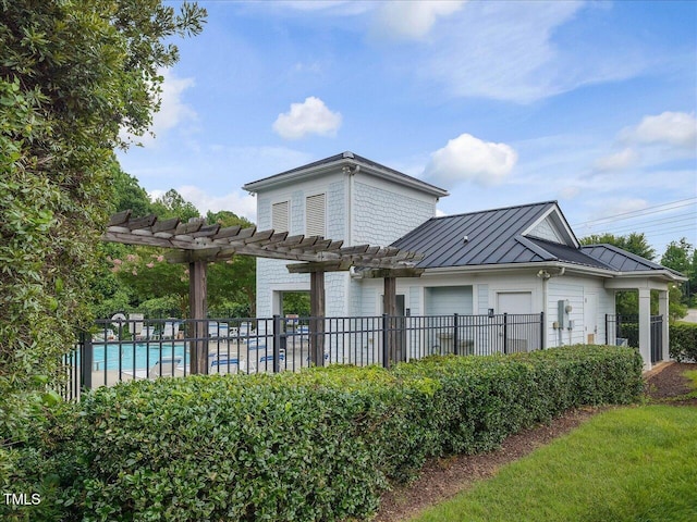 7712 Acc Blvd, Raleigh, NC 27617 - rear view of house featuring a standing seam roof, a pergola, a community pool, and a metal roof
