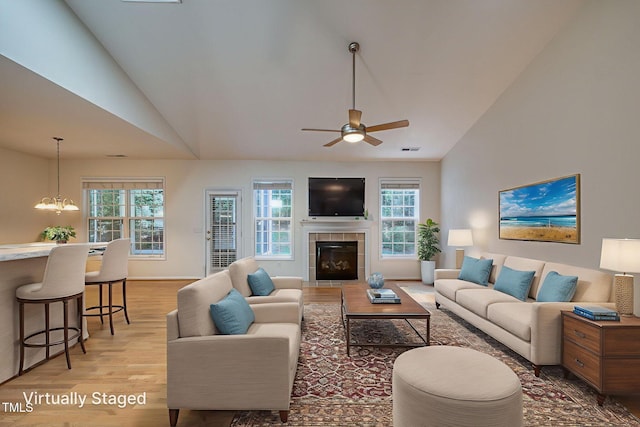 2304 Folger St, Raleigh, NC 27604 - living room with vaulted ceiling, light wood finished floors, healthy amount of natural light, a ceiling fan, and a fireplace